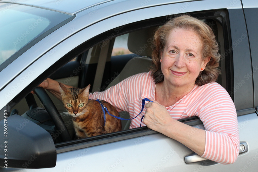 Lovely mature woman taking her cat to a vacation 
