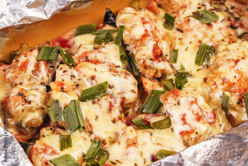 Seafood, Mediterranean cuisine, European dish. Fish baked in a foil with tomatoes, entirely with onion rings, red and green peppers, chili peppers, greens, cheese, mushrooms and vegetables. Caucasian 