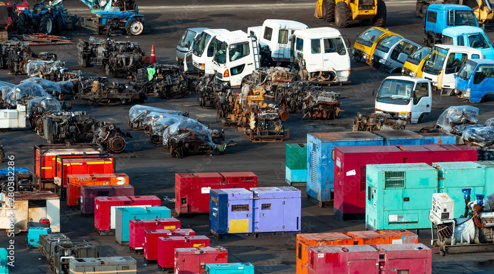 Heavy machinery second hand market. Old electric generator, tractor, diesel  engine on dirty concrete floor. Warehouse of heavy machinery for sale. Used  heavy equipment and diesel engine for sale. Stock Photo