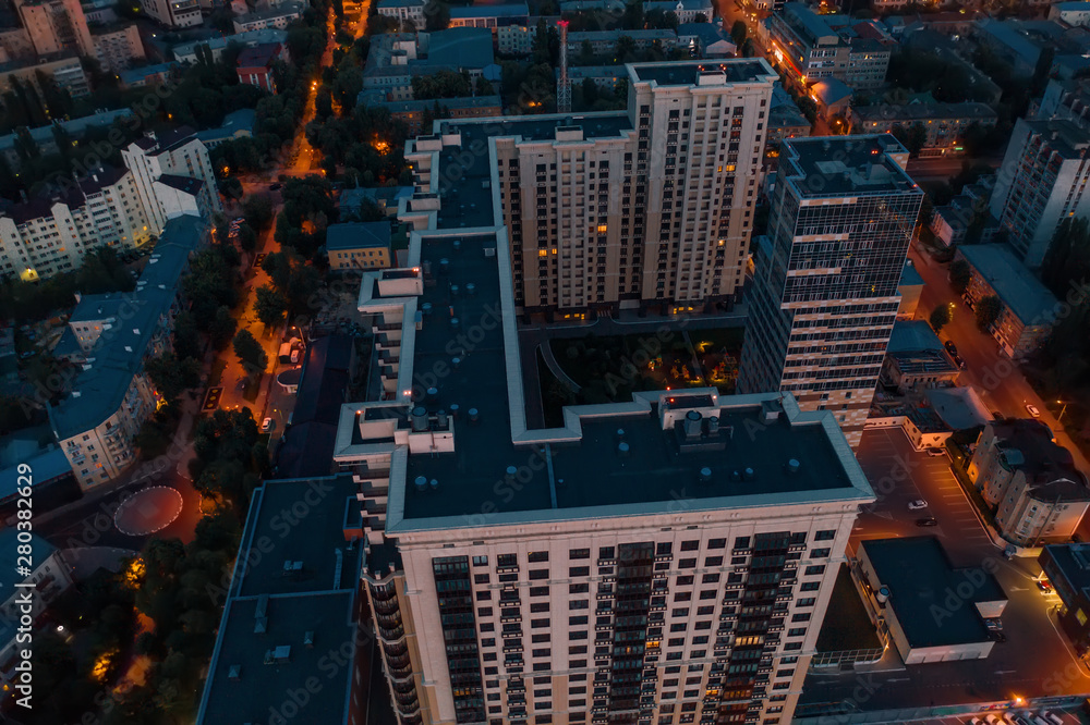 Flight above Night City buildings on drone, aerial view