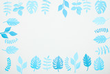 top view of blue paper cut tropical leaves isolated on white with copy space