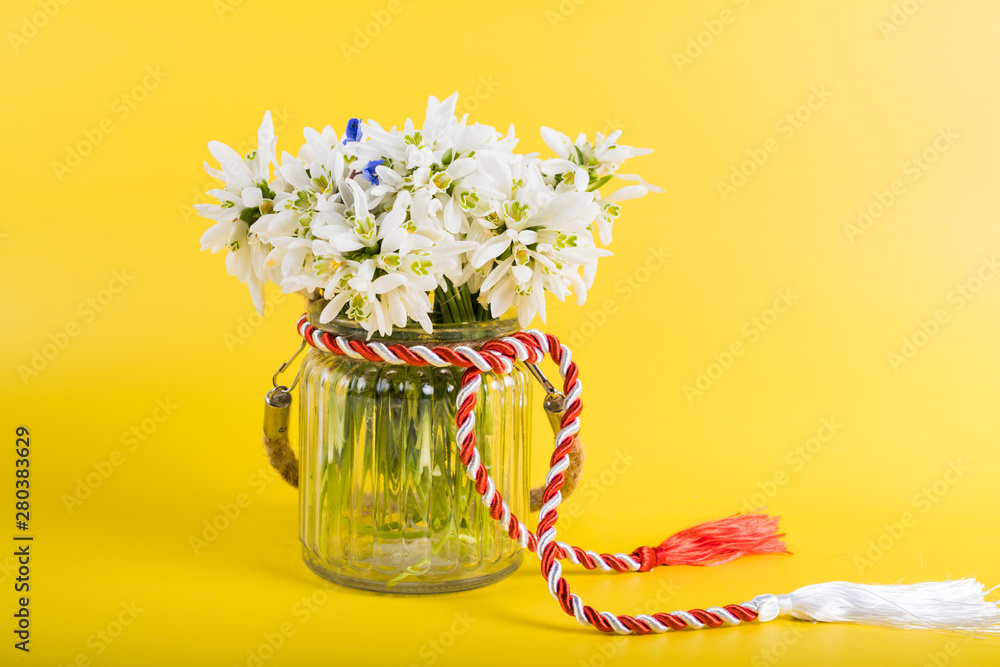 Spring time flowers like snowdrops, hyacinth and roses, isolated on yellow simple background, spring symbol and traditional romanian 
