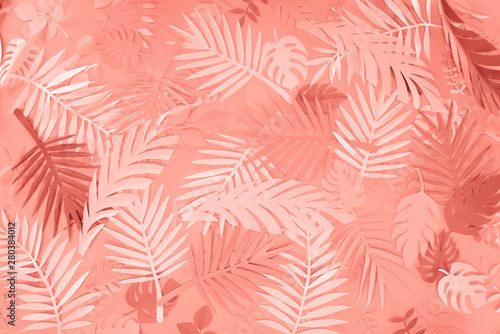 top view of coral tropical paper cut palm leaves, minimalistic background