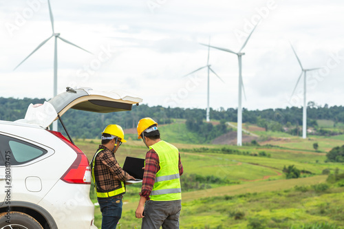 Two Windmill engineer inspection and progress check wind turbine at construction site By using a car as a vehicle.