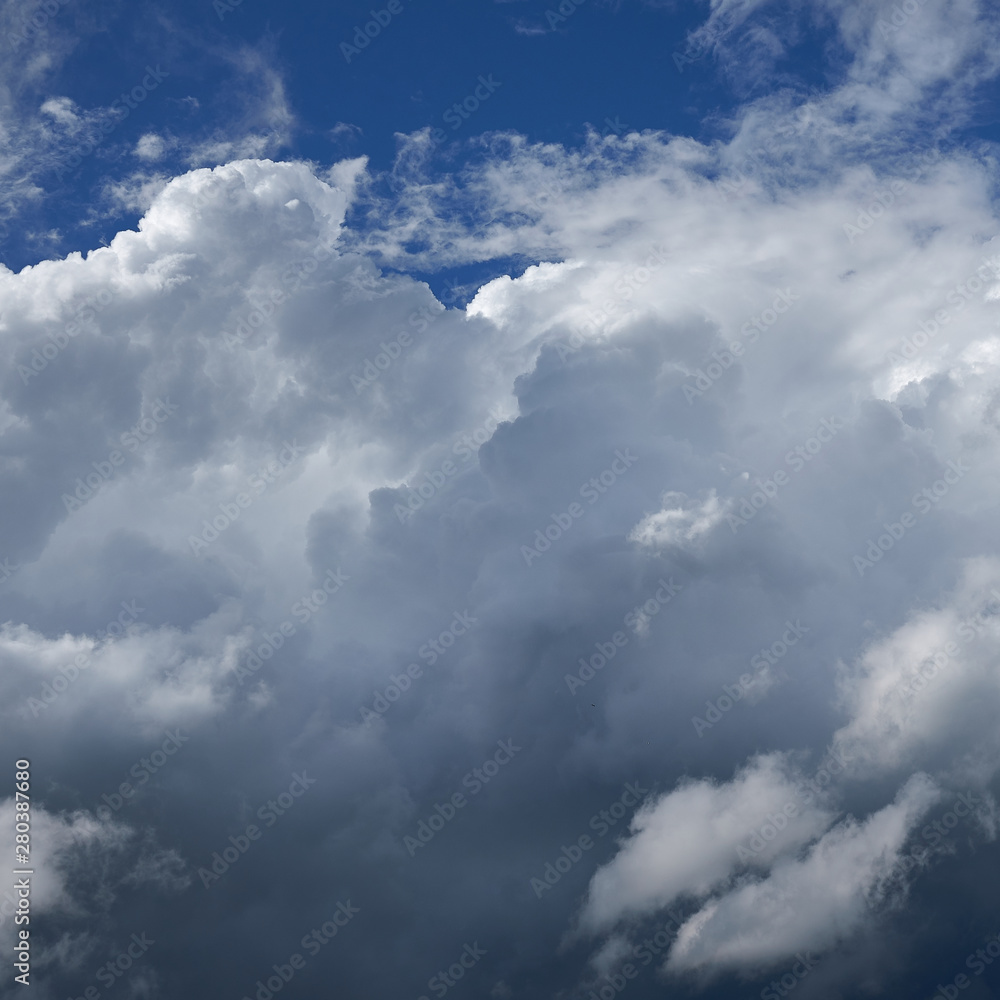 White and dark clouds against a blue sky. White and dark clouds against a blue sky.