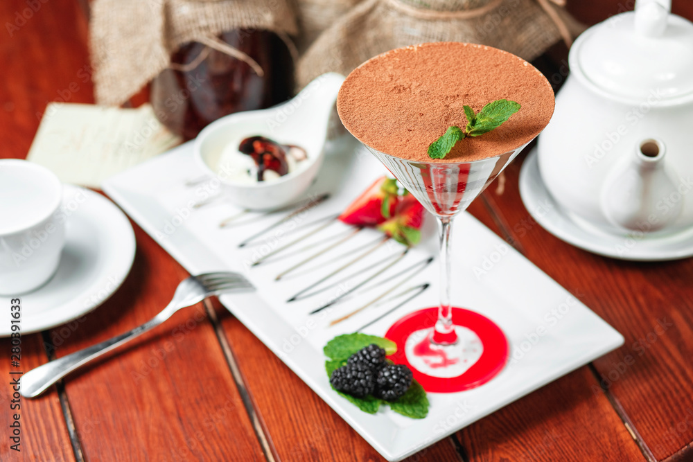 chocolate cake in a cocktail glass with nuts, sprinkled with sweet sauce with berries chocolate cake in a cocktail glass with nuts, sprinkled with sweet sauce with berries