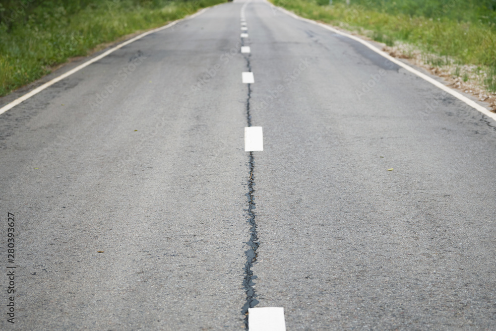 Grey shabby car asphalt road with white dividing lines