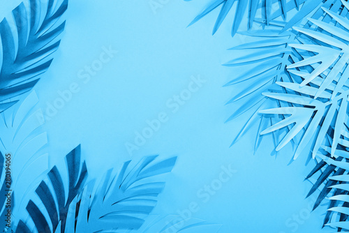 frame of paper leaves on blue minimalistic background with copy space