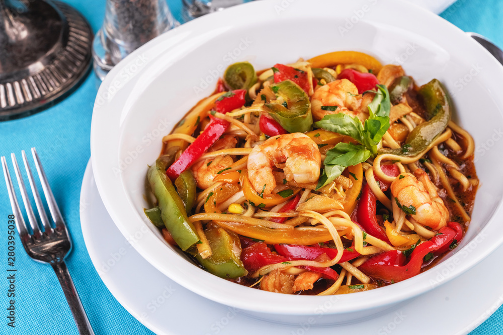 Mediterranean dish, Georgian recipe. Pasta with shrimps, red and green pepper, basil