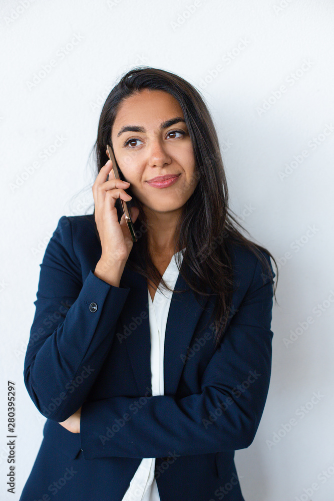Content young woman talking by cell phone. Beautiful smiling young businesswoman talking by smartphone isolated on grey background. Communication concept Content young woman talking by cell phone. Beautiful smiling young businesswoman talking by smartphone isolated on grey background. Communication concept