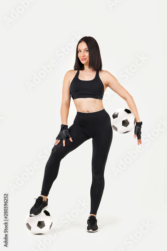 beautiful athletic woman with soccer ball posing isolated on gray background