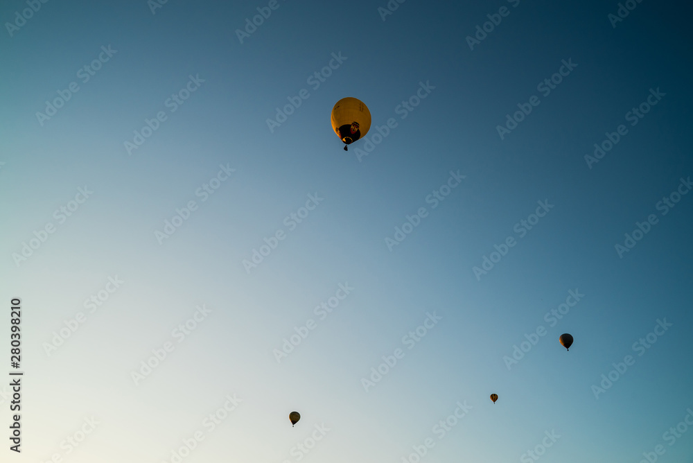 Obraz premium Hot air balloons high in the air. European balloon festival in Spain. Free flow of big colourful balloons flying in the event sky. Beautiful landscapes and evening light. Summer adventures in Spain 