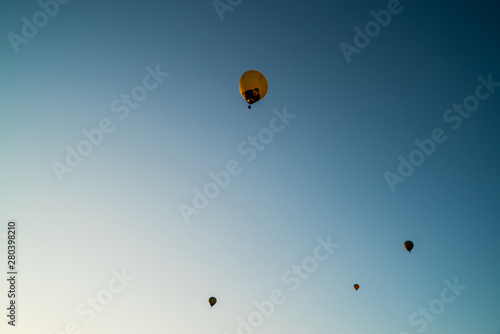 Hot air balloons high in the air. European balloon festival in Spain. Free flow of big colourful balloons flying in the event sky. Beautiful landscapes and evening light. Summer adventures in Spain 
