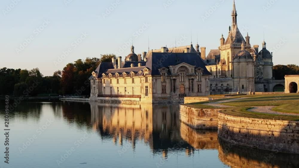 Castle of chantilly at sunset with reflection on pond, oise picardy france Castle of chantilly at sunset with reflection on pond, oise picardy france