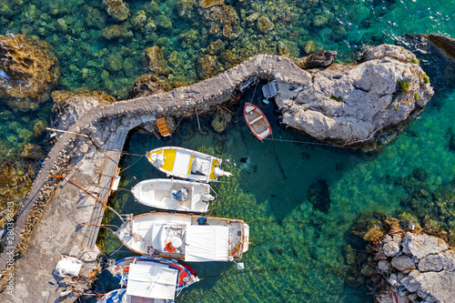 Aerial view of boats on sea water at the rocky seashore.