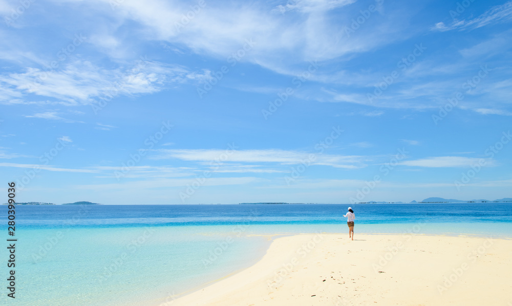 single young girl on tropical white sand beach running toward horizon. Semporna, Sabah, Malaysia single young girl on tropical white sand beach running toward horizon. Semporna, Sabah, Malaysia
