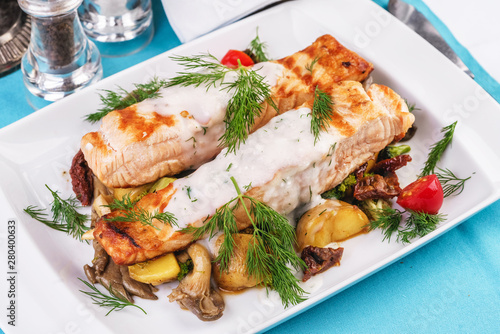 Seafood, Mediterranean cuisine. Grilled salmon fish steak with grilled vegetables and oyster mushrooms. Caucasian kitchen