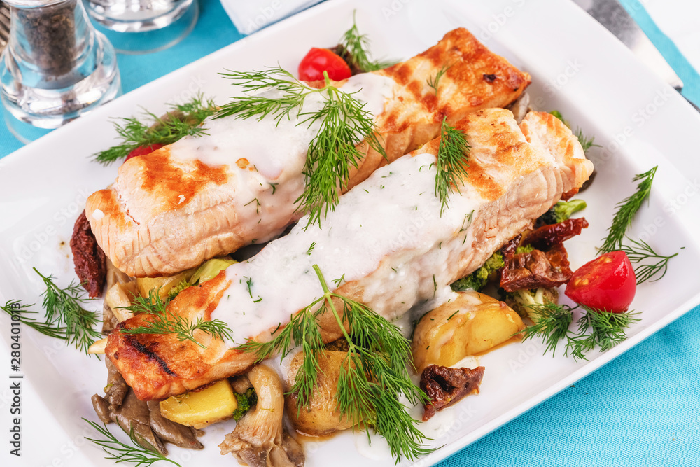 Seafood, Mediterranean cuisine. Grilled salmon fish steak with grilled vegetables and oyster mushrooms. Caucasian kitchen Seafood, Mediterranean cuisine. Grilled salmon fish steak with grilled vegetables and oyster mushrooms. Caucasian kitchen