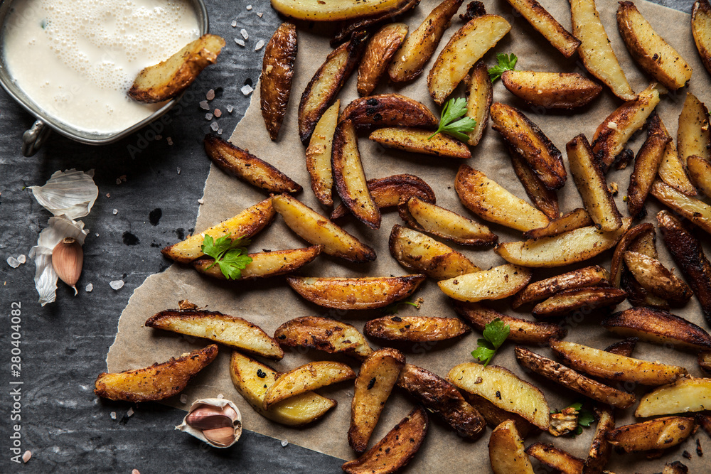 Delicious potatoes with rosemary on parchment, closeup Delicious potatoes with rosemary on parchment, closeup