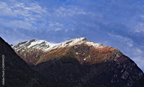 Scenic landscape with snow capped mountain peaks and copy space. Brown autumn color with first snow on peak.