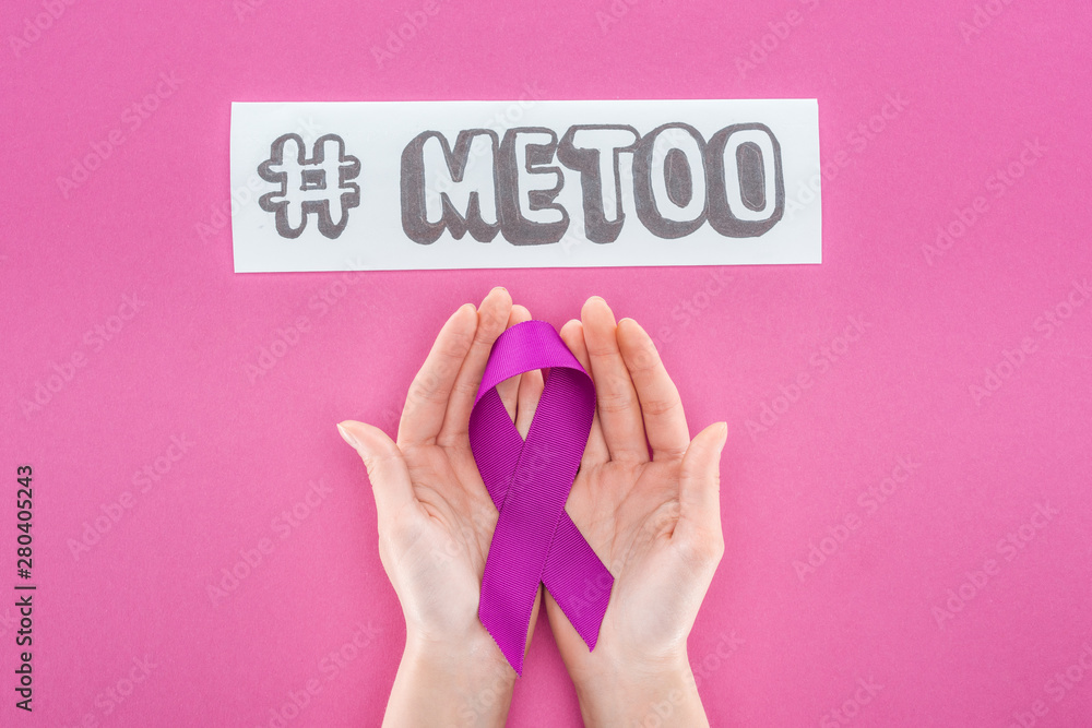 cropped view of woman holding purple awareness ribbon near paper with hashtag me too isolated on pink cropped view of woman holding purple awareness ribbon near paper with hashtag me too isolated on pink