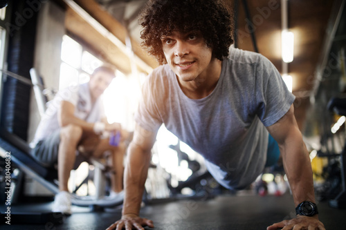 Portrait of a handsome man doing push ups exercise in gym