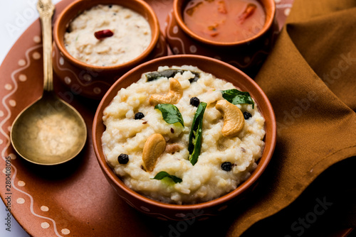 Ven pongal recipe is a popular South Indian food prepared with rice & moong dal and served with sambar and coconut chutney, selective focus