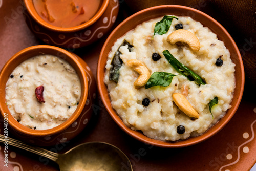 Ven pongal recipe is a popular South Indian food prepared with rice & moong dal and served with sambar and coconut chutney, selective focus