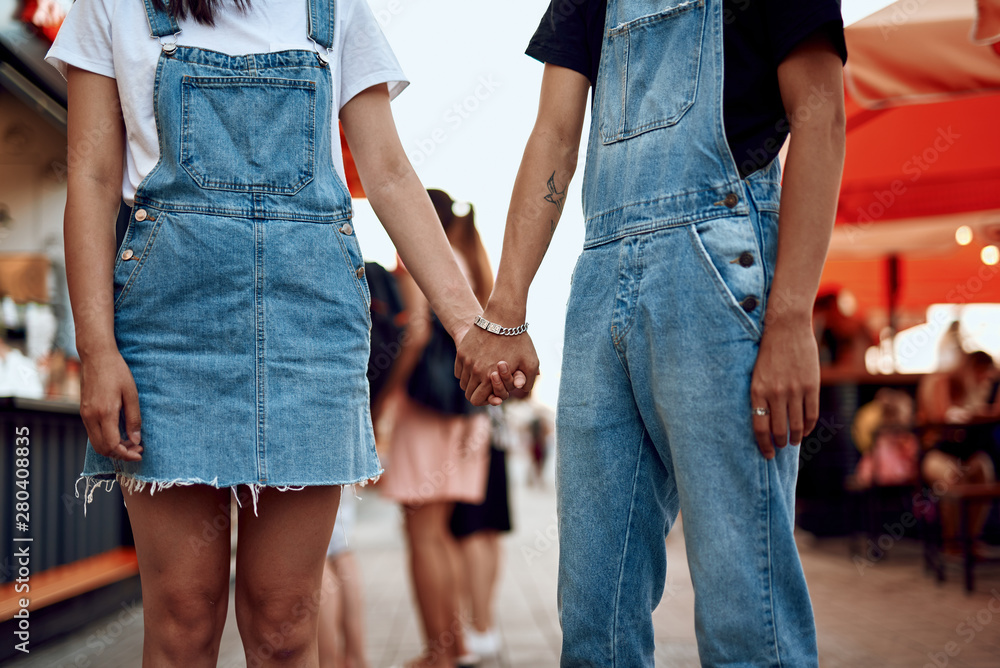 Happy couple holding hands on city background Happy couple holding hands on city background