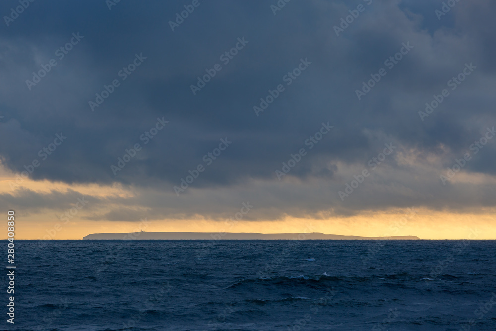 Lundy Island at sunset with stormy sky