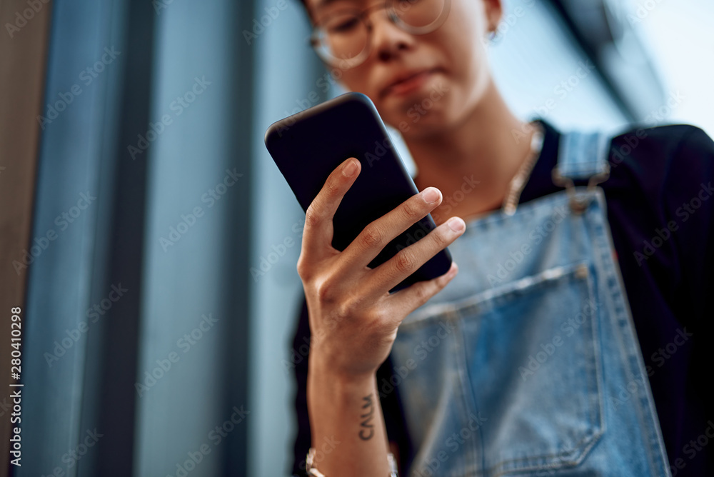 Hipster asian guy looking at mobile phone Hipster asian guy looking at mobile phone