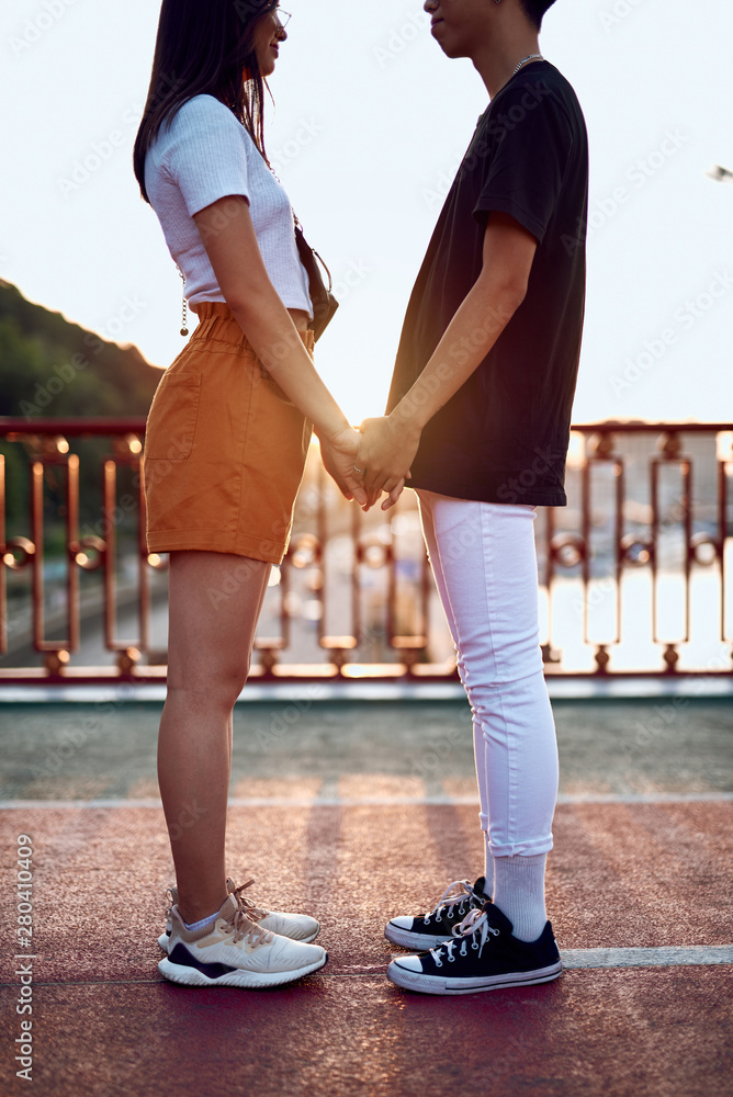Fototapeta premium Young happy lovers staying together holding hands
