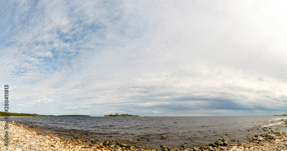 The sky above the pebble beach on the lake.