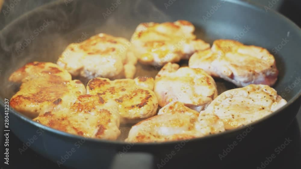 Fresh chicken pieces are cooked in frying pan. Fresh chicken pieces are cooked in frying pan.