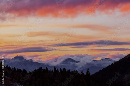 Panorama silhouette forest and mountain tops in red orange blue clouds gradient sunset