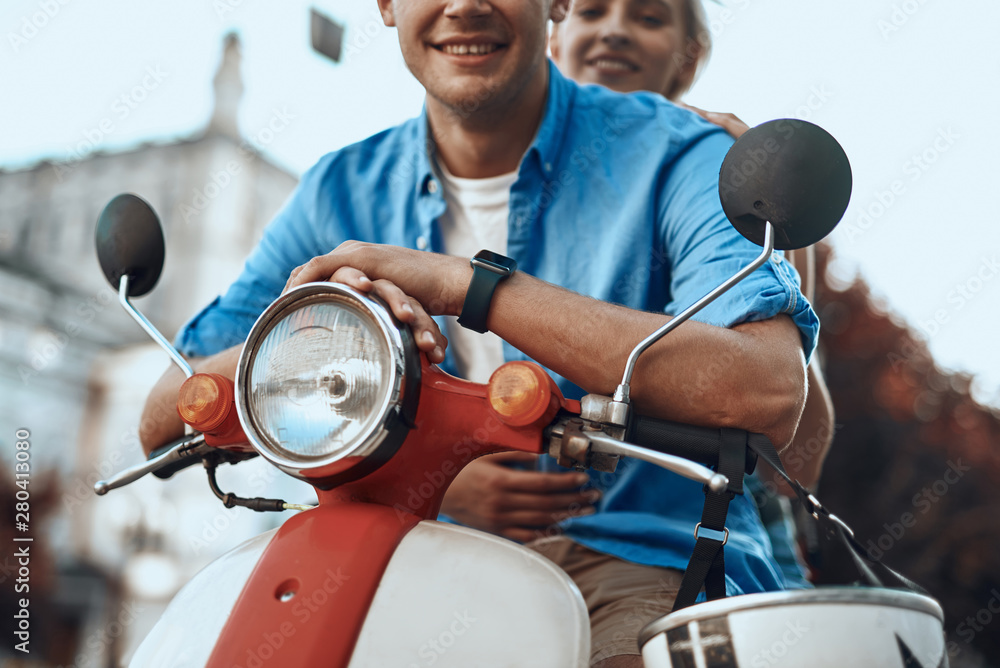 Man and woman on the red motorbike smiling