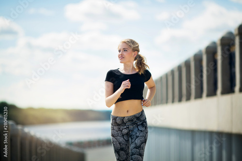 beautiful young woman in summer engaged in jogging