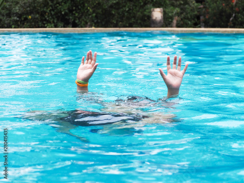 Active Boy diving and raising hands in the air at outdoor swimming pool