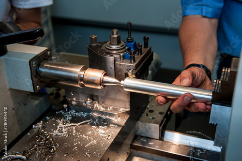 Arbeiter mit Werkstück an der Drehmaschine, Nahaufnahme