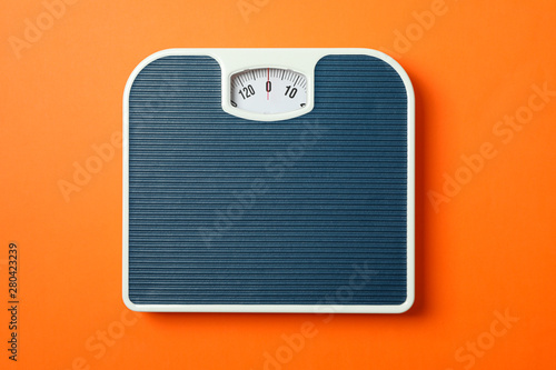 Blue weigh scales on orange background, top view photo