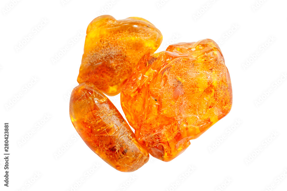 Amber. Three pieces of transparent yellow amber on a white background. Sun stone. Natural mineral fossilized ancient resin. Material for jewelry products. Yellow colored stone Amber. Three pieces of transparent yellow amber on a white background. Sun stone. Natural mineral fossilized ancient resin. Material for jewelry products. Yellow colored stone