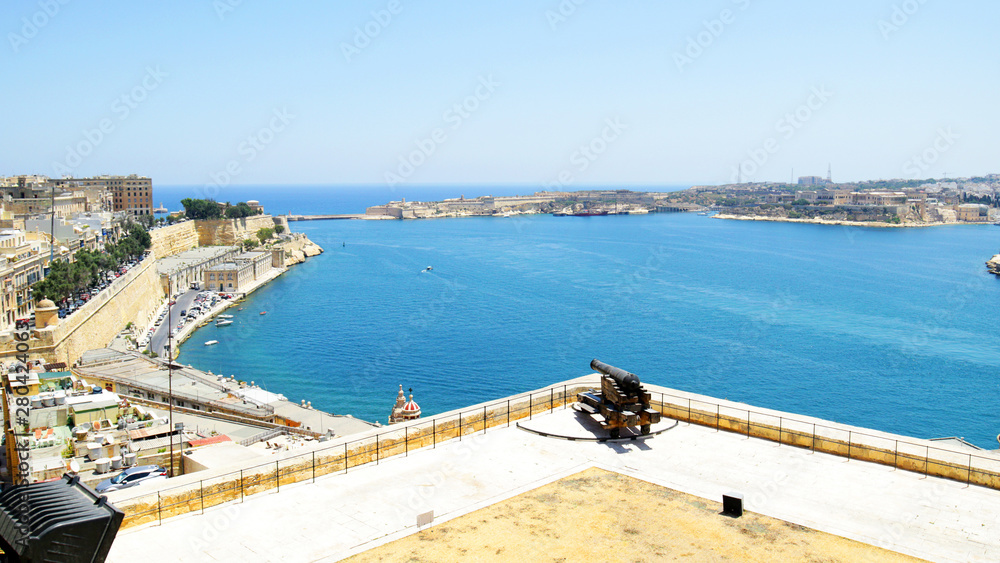 Grand Harbour of Valletta, Malta.  Medieval forts with bastions,  View from Upper Barrakka Garden.  Antique Cannon  from Old Fort.