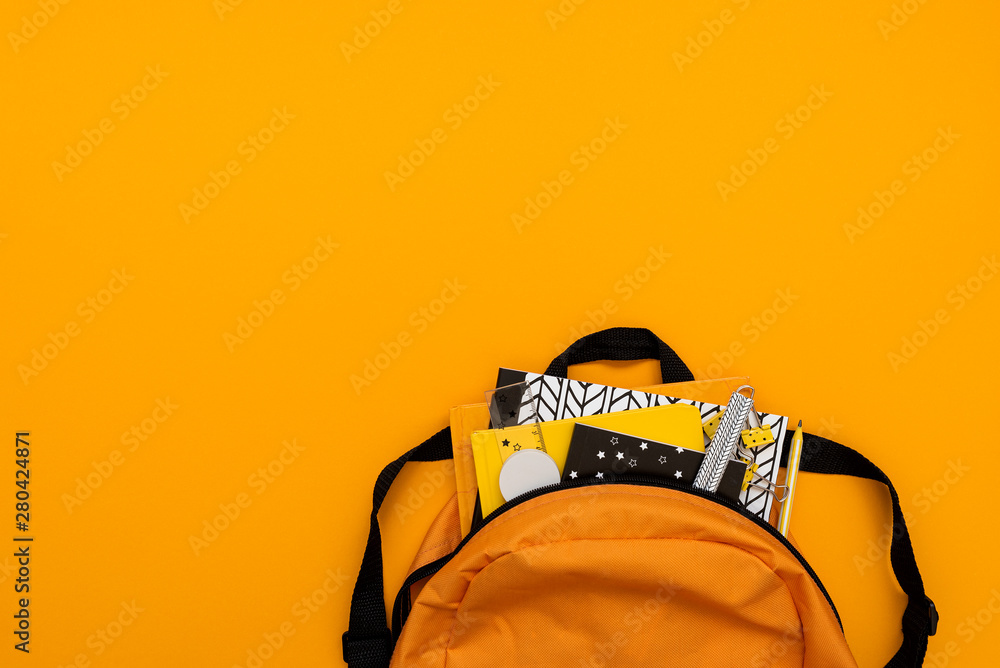 Back to school concept. Backpack with school supplies on yellow background. Top view. Copy space. Flat lay - obrazy, fototapety, plakaty 