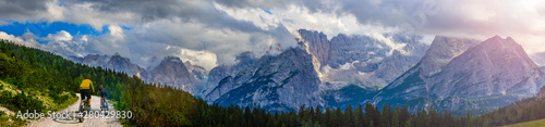 Cycling woman and man riding on bikes in Dolomites mountains andscape. Couple cycling MTB enduro trail track. Outdoor sport activity.