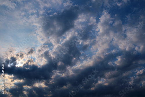 The sun's ray passes through the cirrus clouds in the blue sky.