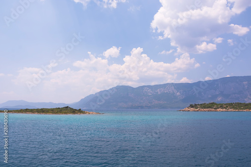 Aegean Islands and yacht on mountains and blue sky background, Turkey. Tropical wallpaper, paradise beach