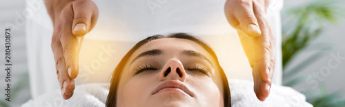 Billede på lærred panoramic shot of healer standing near patient on massage table and cleaning aur