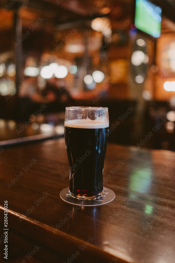dark stout beer at a pub - obrazy, fototapety, plakaty 