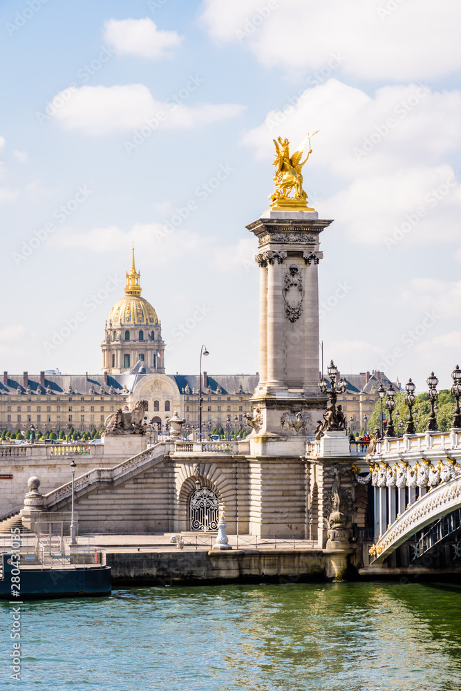 The pont Alexandre III over the river Seine in Paris, France, with the dome des Invalides in the background on a sunny summer morning.