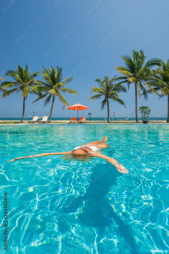 Beautiful woman relaxing in a pool at summer Beautiful woman relaxing in a pool at summer